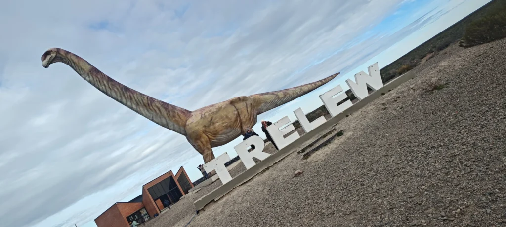 Giant dinosaur replica and Trelew city sign in Patagonia, Argentina.